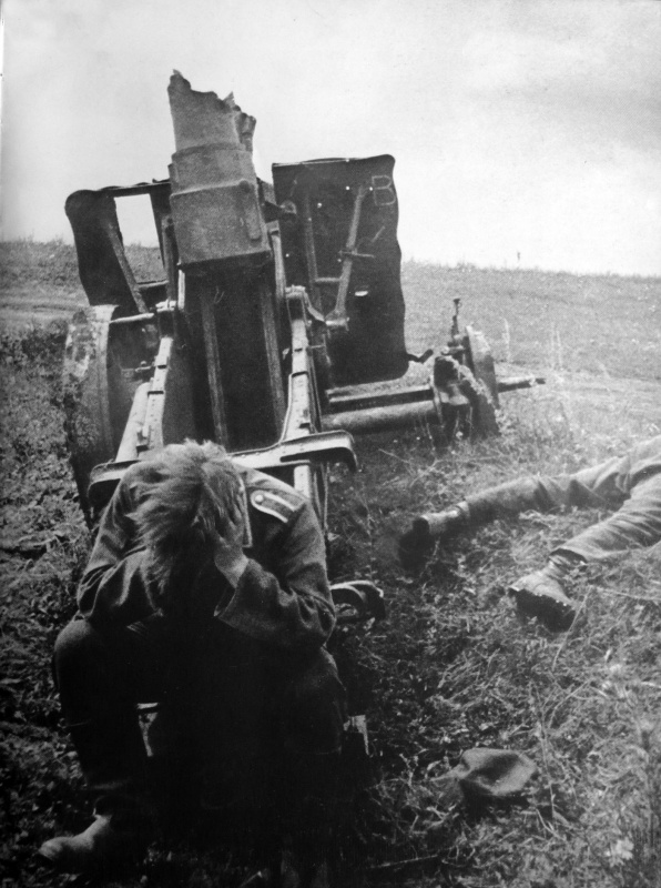 Немецкий военнопленный на Курской дуге у разбитой 150-мм пехотной пушки sIG.33.