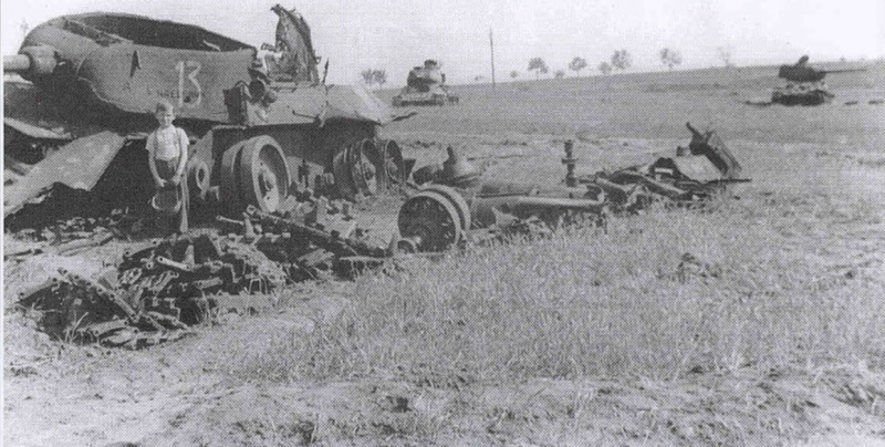 Мальчик лет семи на месте прошедшего боя, у взорванного советского танка Т-34-85. Позади видны еще два таких же танка.
