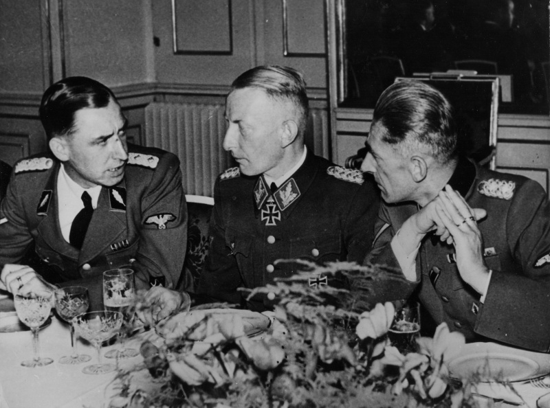 На фото слева направо штандартенфюрер СС Ерих Вайнманн , бригаденфюрер СС Генрих Райнфарт и Карл Франк на банкете в честь подавления Варшавского восстания.