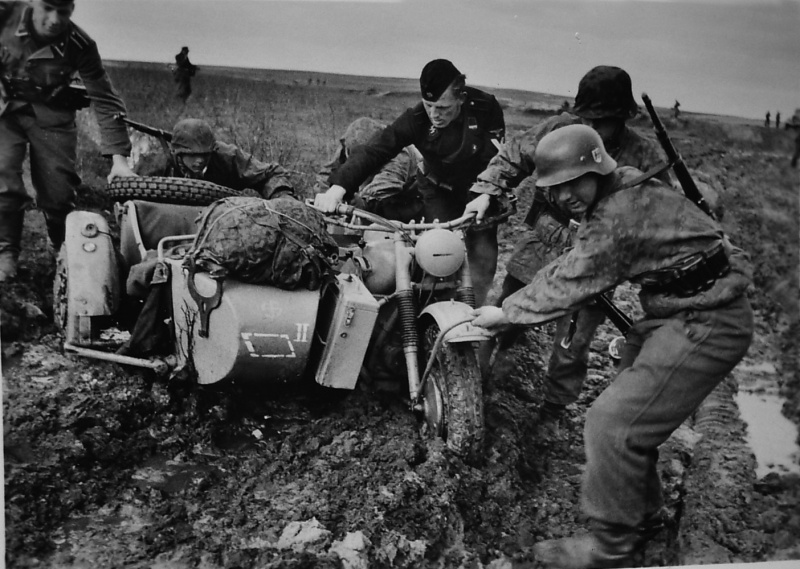 Немецкие солдаты из состава 5-й танковой дивизии СС «Викинг» вытаскивают мотоцикл из грязи.