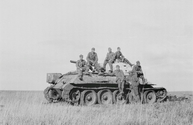 Немецкие солдаты на подбитом в поле советском танке Т-34. По характерным признакам машина выпуска апреля 1943 года и производства завода №112 «Красное Сормово». Рядом с танком лежат снаряды из танка